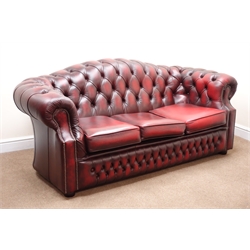  Three seat Chesterfield sofa arched back, upholstered in deep buttoned Burgundy leather, bun feet (W188cm) with similar square storage footstool (W48cm, H48cm, D48cm) (2)  