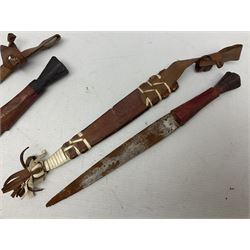 Indian kukri with 29cm curving steel blade and nickel mounted horn grip; in leather covered scabbard with one skinning knife L42cm overall; Hitler Youth knife with scabbard in relic condition; and three African graduated knives each with crudely carved wooden grips and painted leather covered scabbards (5)