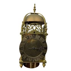 A 20th century replica of a 17th century 30-hour lantern clock with a rope driven verge escapement and countwheel striking, sounding the hours on a bell, with an engraved dial centre, silvered chapter ring and Roman numerals , half hour and quarter hour markers and a pierced and fettled steel hand, with an attached disc engraved “ Clockmaker In Scarborough Ivan Coe, Fecit,”, with engraved side doors, brass finials and dolphin fretwork, on a wooden bracket with pulley.   No weight.
Clocks similar to this were usually individually constructed by engineers working from plans of clocks designed by Claude Reeve, John Wilding, Malcolm Timings and other well-known clockmakers/engineers. 
