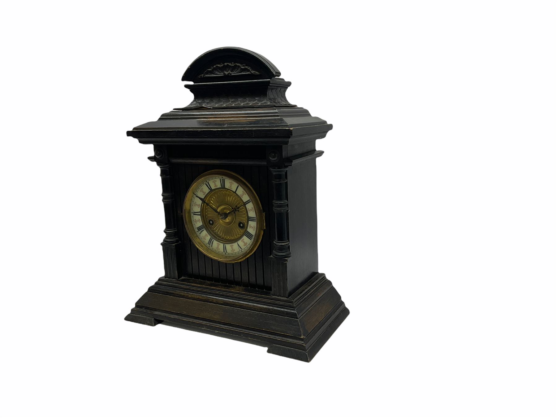 An early 20th century fourteen-day German mantle clock in a wooden case striking the hours on a coiled gong, two-part dial with a gilt centre, ivorine chapter ring with roman numerals, minute track and half-hour markers, steel Fleur de Lys hands and brass spun bezel, case on a splayed stepped plinth with cluster columns, wide cornice and carved broken arch pediment, original Hamburg American Clock Company (HAC) trade labels attached inside the case door.