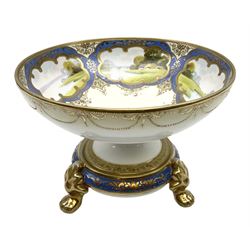 Noritake twin handled pedestal bowl, the interior painted with European river landscape scenes against a blue and gilt ground, raised on stand with leaf and paw feet, H18cm