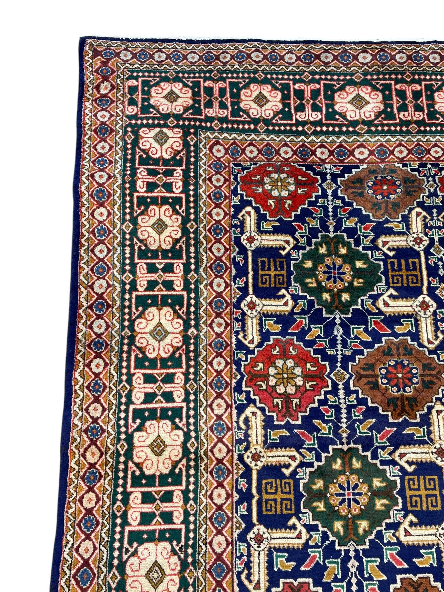 Persian Tabriz indigo ground rug, overall Quba design, decorated with repeating stylised plant motifs and interlaced with trailing leaf motifs, repeating border within geometric guard stripes