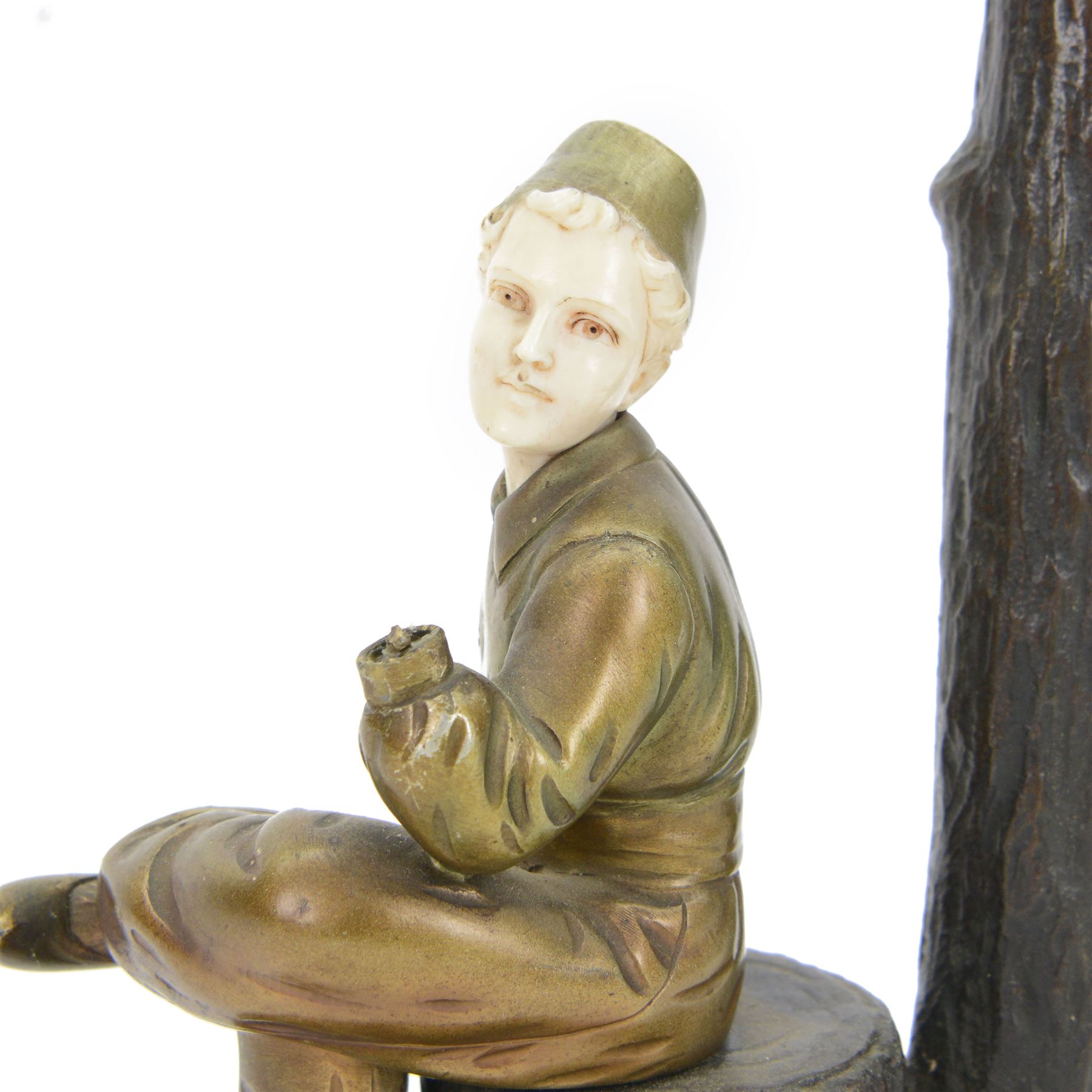 Professor Otto Poertzel (German, 1876-1963): gilt bronze and carved ivory figure, circa 1920-1930, modelled as a young dutch man seated upon a tree stump spreading to a naturalistically modelled rounded base, with light fitting behind modelled as a tree branch, supporting a circular cream and tasseled shade, signed in the case Poertzel, also bearing foundry mark RVM, including shade overall H43.5cm
This item has been registered for sale under Section 10 of the APHA Ivory Act
