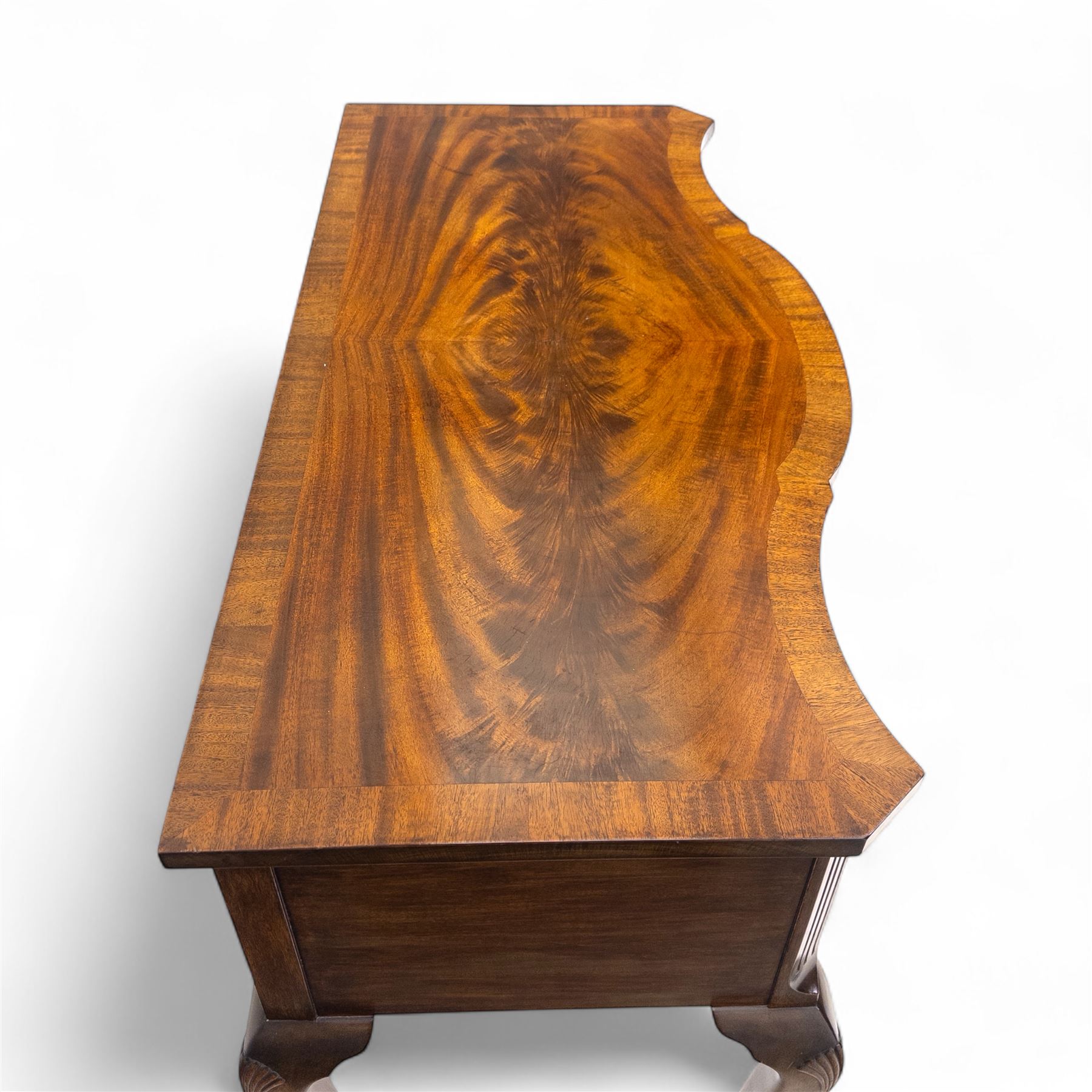 20th century figured walnut serpentine dressing table, moulded top with book-matched veneers over an arrangement of five drawers fitted with brass swan neck handles, on cabriole supports with shell carved knees