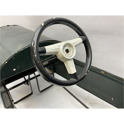 Mid 20th century pressed steel pedal car, the body painted in dark green fitted with pretend radiator to the bonnet, with spoked wheels and rubber tyres, the interior with pedals and steering wheel, L70cm