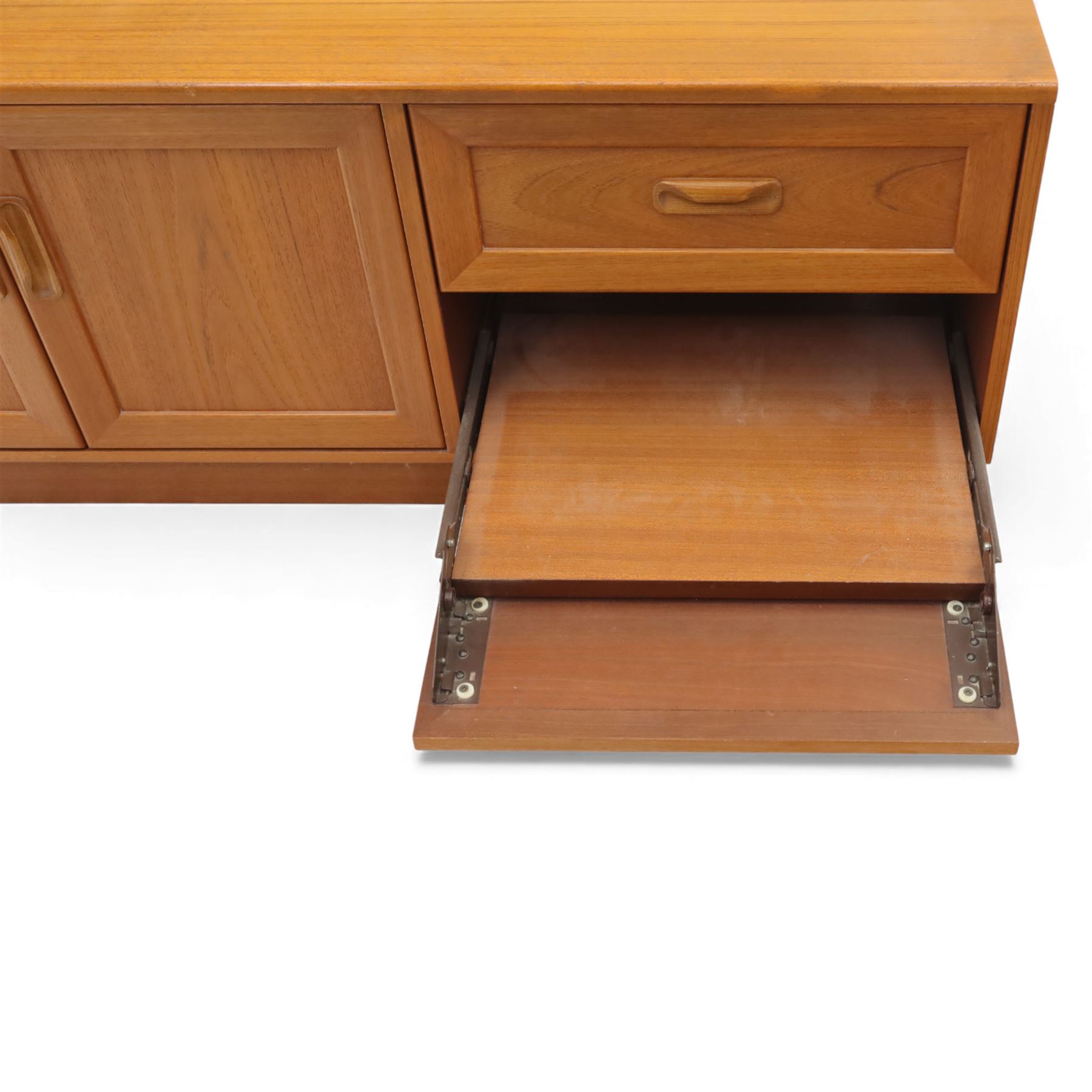 G Plan - 'Fresco' teak side unit, rectangular top above twin cupboard doors and two drawers, drawers fitted with cassette tape storage and a fall front drawer, raised on a plinth base