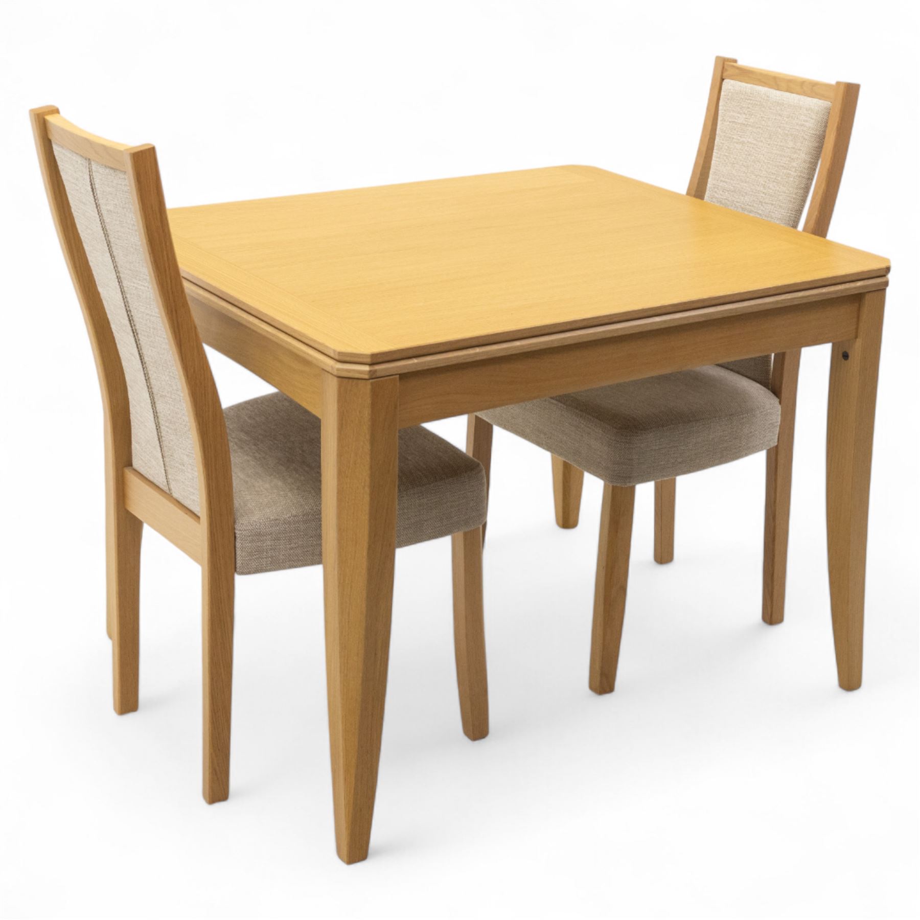 Ercol - light oak ‘Artisan’ rectangular dining table with chamfered top extending fold over top and tapered legs, together with two matching high back dining chairs upholstered in textured beige fabric (Chairs H 98cm, W 47cm, D 52cm)