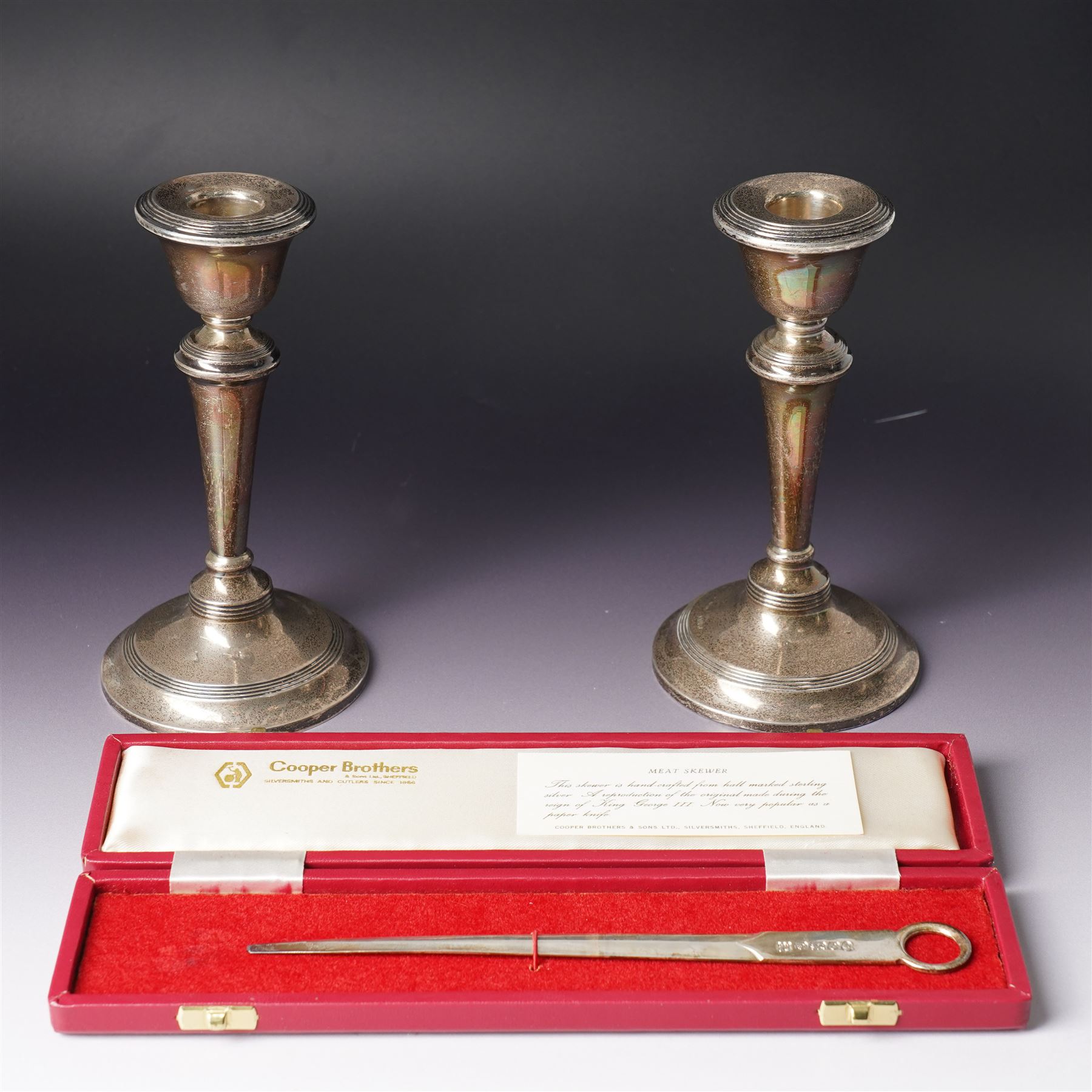 Pair of Edwardian silver candlesticks H16cm Chester 1908 Maker S Blanckensee & Son Ltd and a silver meat skewer/ paper knife, cased Sheffield 1977 Maker Cooper Bros