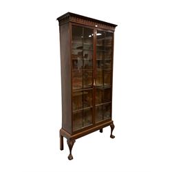 George III mahogany bookcase on stand, the projecting arcade carved cornice with turned split spindles, fitted with two astragal glazed doors enclosing five adjustable shelves, the stand with cartouche and scroll carved cabriole supports terminating in ball and claw feet