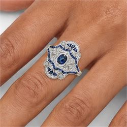 Platinum sapphire and diamond dress ring, milgrain set with a single oval cut sapphire, surrounded by single cut diamonds, calibre and vari-cut sapphires, in an pierced design setting, stamped PT 950, total sapphire weight 0.87 carat, total diamond weight 0.45 carat