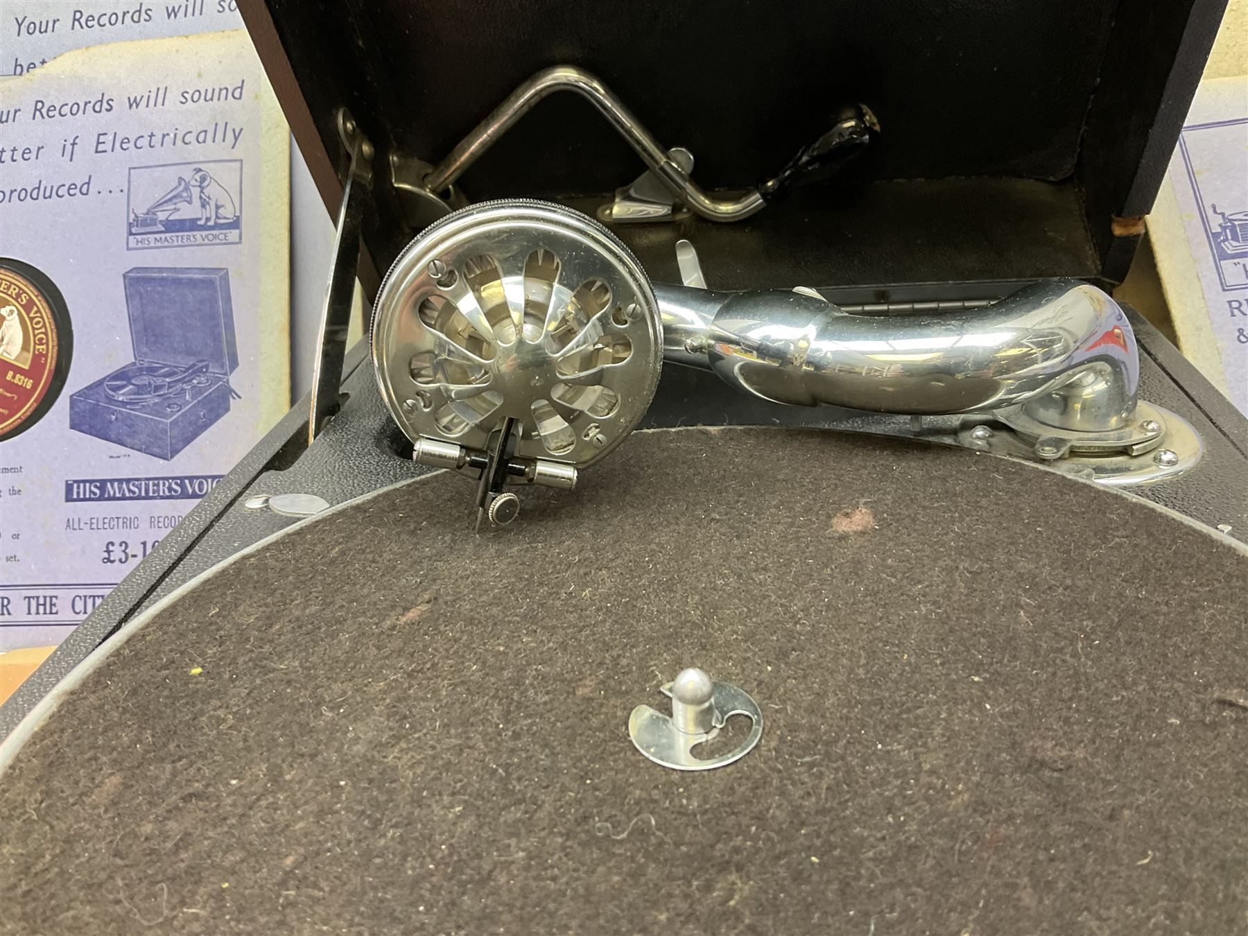 HMV portable wind up gramophone in a black case, together with a collection of records. 