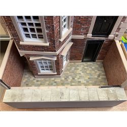 'The Hollies' - good quality sectional wooden doll's house in the form of a Georgian style four-storey bay windowed town house with simulated brick front elevation, rendered sides, off-set corner stonework, faux slate-hung top floor with flat roof and chimney stack, working sash windows, iron railings around front basement courtyard with hinged front elevation to two rooms with  spiral staircase, side hinged central section approached by external steps with iron balustrades to the sides leading to a front door, entrance hall with stairs to landing and two rooms on two floors with dado panelling and fire-surrounds, the top floor with top hung front elevation revealing stairs to a landing and bedroom; wired for electricity L51cm D65cm H107cm including chimney; together with a good quantity of quality wooden furniture and accessories including piano, dressers, bookcase and books, rugs, double half-tester bed, metalware, pictures etc