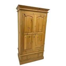 Solid pine double wardrobe enclosed by two panelled doors over single drawers