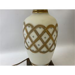 Pair of milk glass lamps of baluster form, decorated with gilded lattice panel raised upon brushed metal raised plinth, with patterned cream fabric shades, approx H78cm