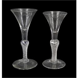Two 18th century drinking glasses, the trumpet bowls upon single series air twist baluster stems and conical feet, tallest H18cm