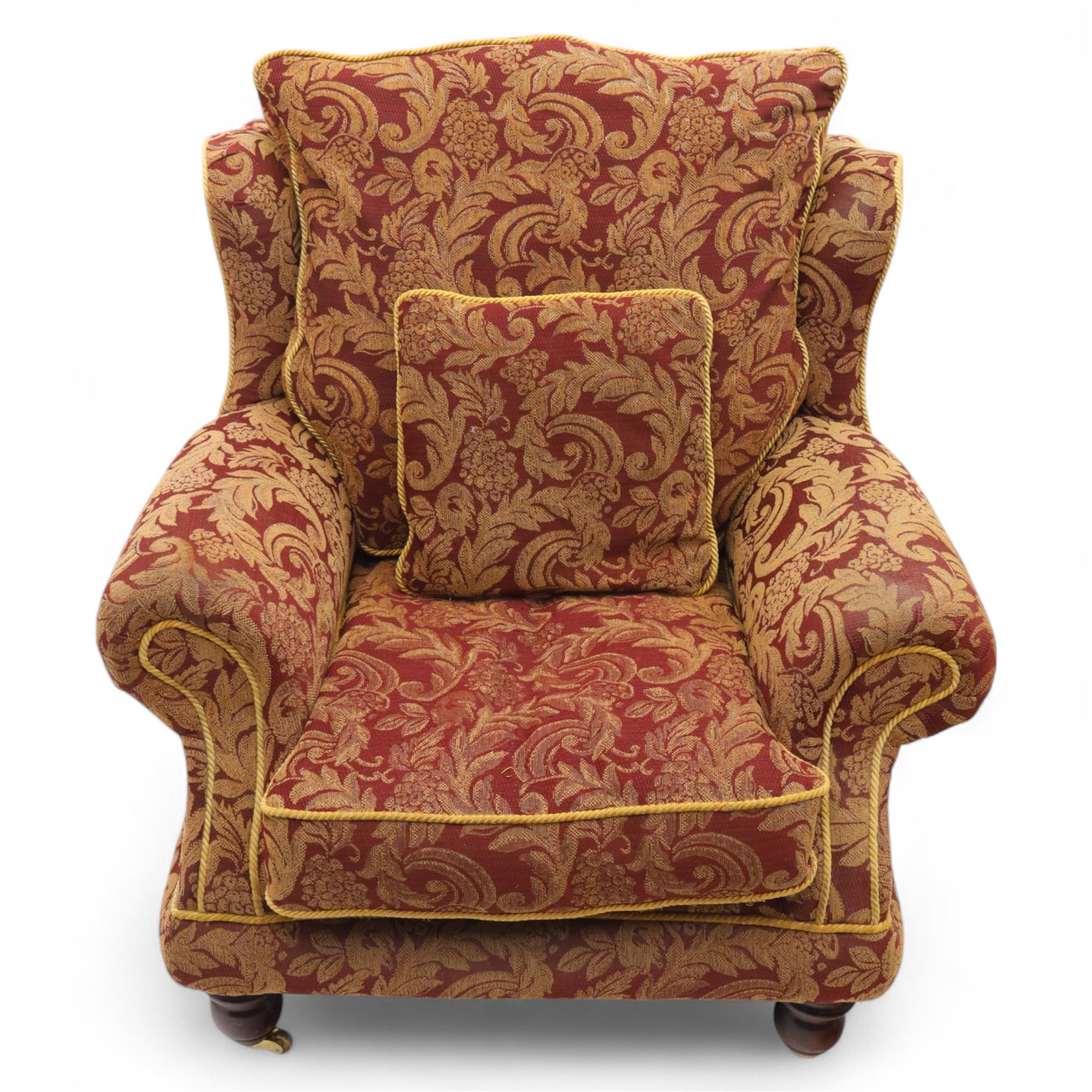 Duresta – pair of armchairs, upholstered in red and gold damask fabric with piped edges, scroll arms and loose feather-filled cushions, raised on turned wooden feet with brass castors