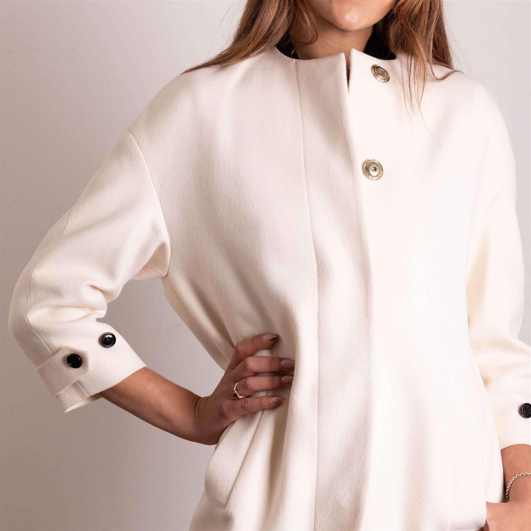Burberry London - wool coat in cream, with concealed front popper fastening, bracelet-length sleeves with tab and black button detail and side slip pockets, with slit to back, size 40, unused with original Harvey Nichols garment bag and hanger