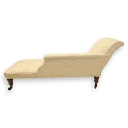 Victorian chaise longue upholstered in ivory damask fabric, padded back and armrest with rope piping, raised on turned feet with castors