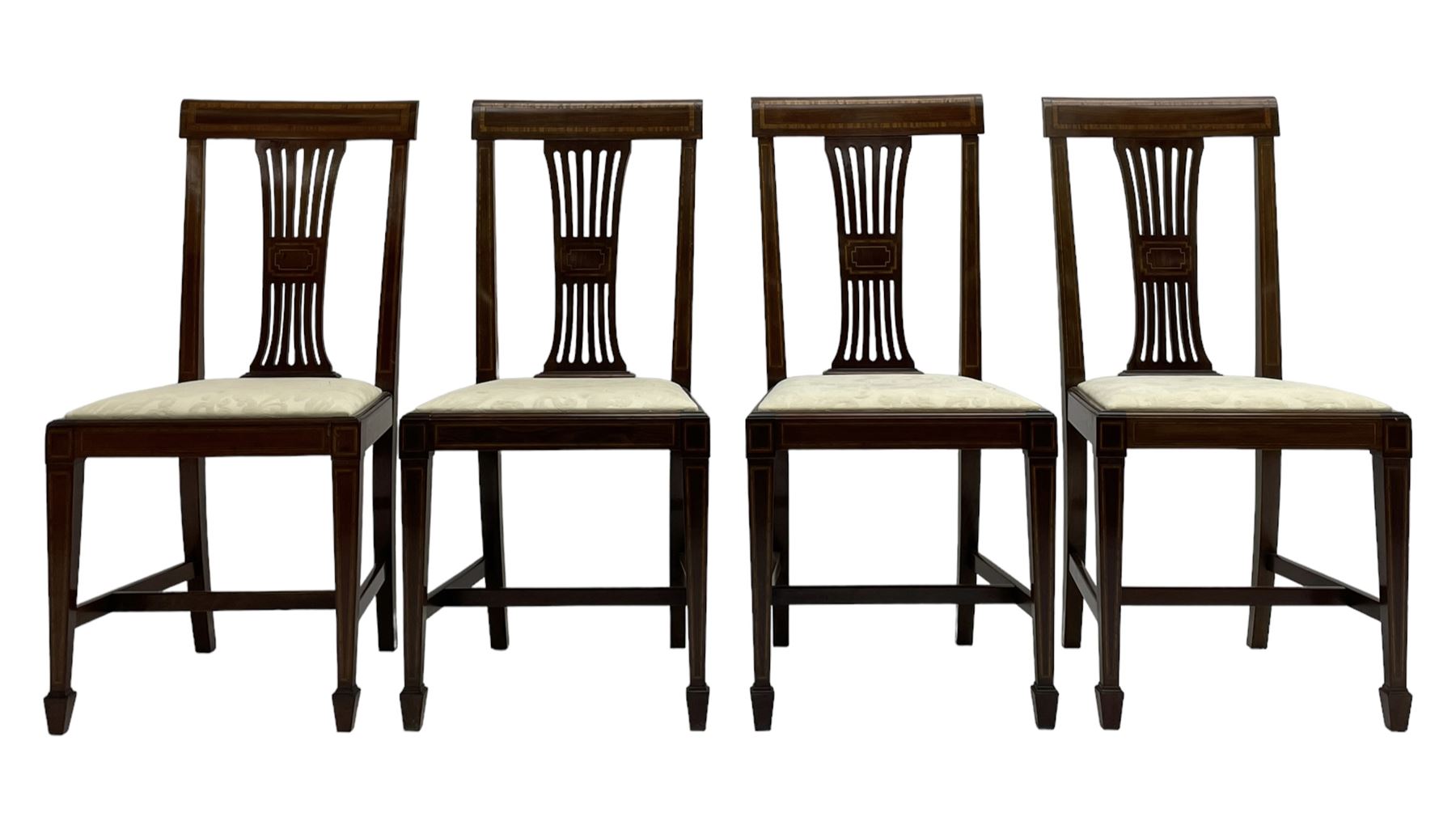 Set twelve (4+8) Edwardian inlaid mahogany dining chairs, cresting rail with satinwood banding, pierced splat backs with central inlay, drop-in seats upholstered in foliate patterned ivory fabric, raised on square tapering supports terminating in spade feet