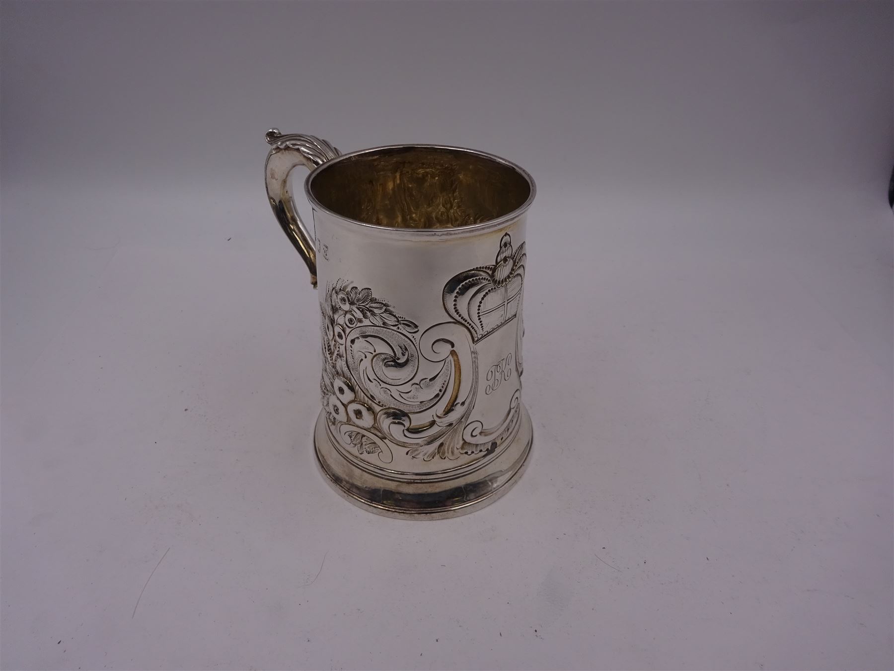 George III silver tankard, of slightly tapering cylindrical from, with chased and repousse crown above a monogrammed cartouche and floral, foliate and C scroll decoration, with acanthus capped C scroll handle, hallmarked WT, possibly William Turton, London 1774, H11.5cm