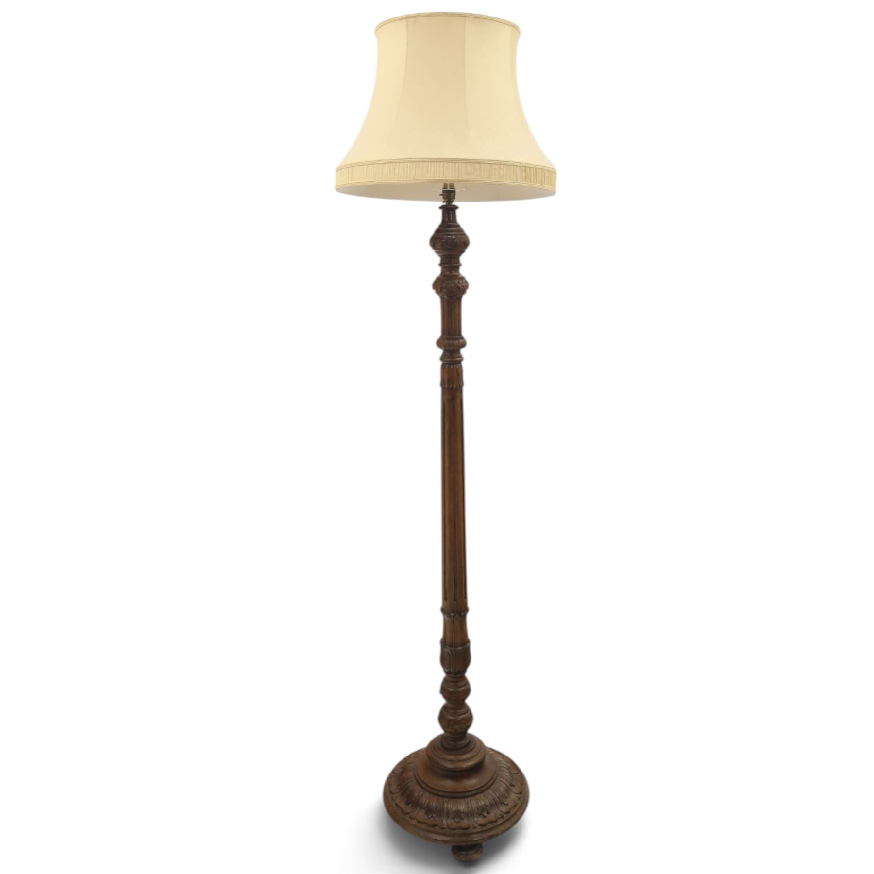 Late 19th Century mahogany standard lamp with shade, canvas beige shade, above a carved and turned column, on a carved base with pad feet