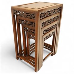 Early 20th century Chinese style hardwood quartetto nest of tables, each with panelled top and carved and pierced vine motif frieze, on square legs united by straight stretchers