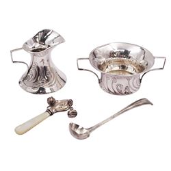 Art Nouveau silver milk jug and twin handled open sucrier, each with chased floral decoration and angular handles, hallmarked Jones & Crompton, Birmingham 1904, together with a George II salt spoon and a mother of pearl handled silver rattle, both hallmarked, milk jug H6cm