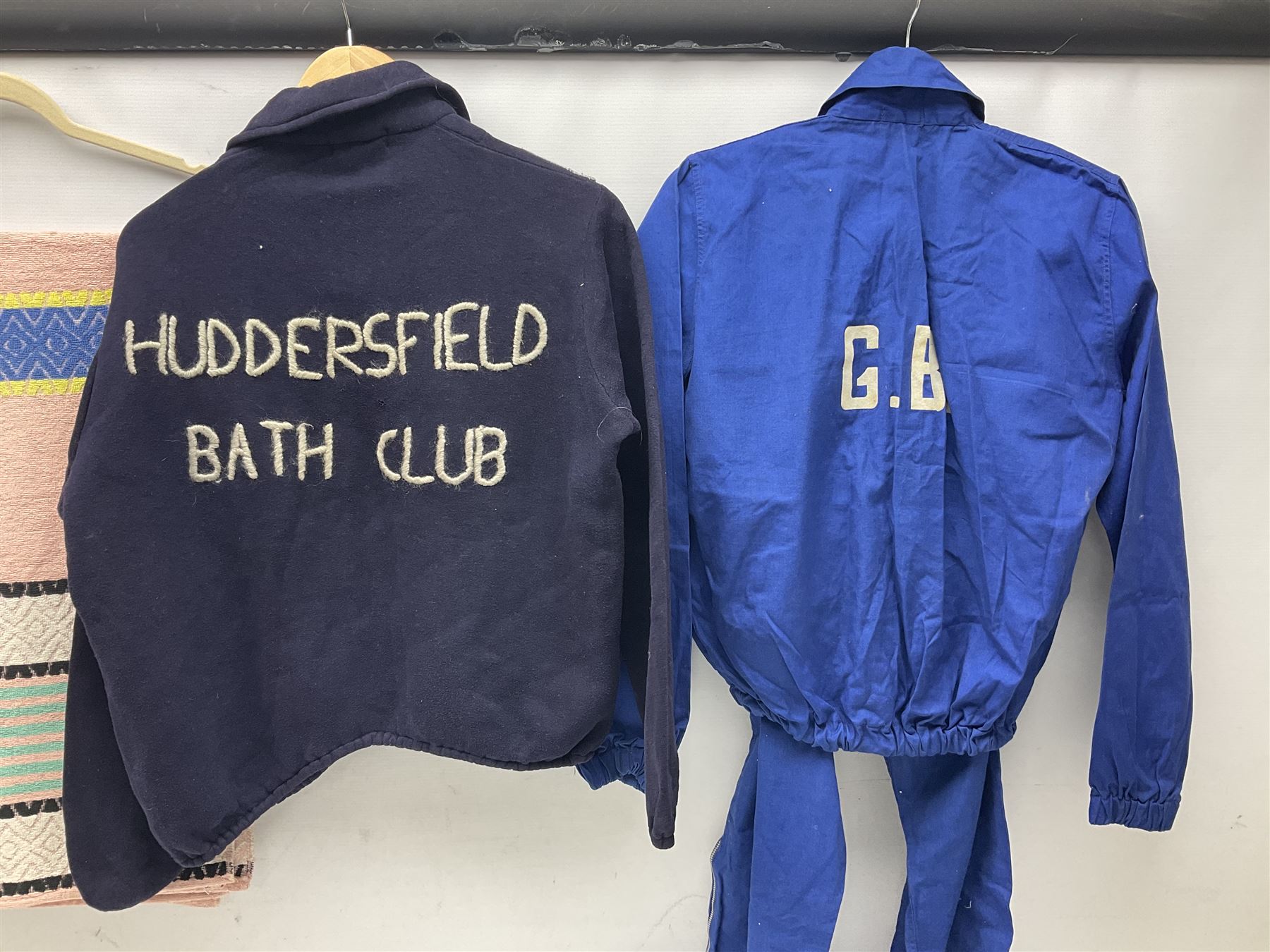 On the direct instructions of Anita Porter nee Lonsbrough Great British Olympic and Commonwealth Games gold medal winning swimmer - collection of early and international memorabilia comprising original Huddersfield Bath Club track suit top bearing eight stitched on cloth badges including British Empire & Commonwealth Games 1958 England Team, YSASA, North Eastern Counties ASA, ESSA Division 3,  English Schools Swimming Association winner etc
The swimming costume Anita wore at the 1958 Commonwealth Games in Cardiff, her first major championships, where she won two gold medals. The grey elastic on the sides, in those days, she would use to make it tighter and more streamlined.
Blue track suit from the 1960 Olympics which she wore on the podium receiving the gold medal.
1960 pool side towelling robe used at the Rome Olympics (interesting to note her name is spelt wrong on the embroidered label).
1962 Commonwealth Games pool side towelling robe used in Perth Australia when winning three Gold medals. 
It was also this year she became BBC Sports Personality of the year, the first female to do so.
Her 'lucky' pool side towel which she took with her to every event she competed in and which can be seen round her neck in many official celebratory photographs. Copies of some of these photographs are included for identification.
In addition there are two souvenir programmes of an evening event to honour Anita at The Theatre Royal Huddersfield and she has kindly signed the front cover on one of these.