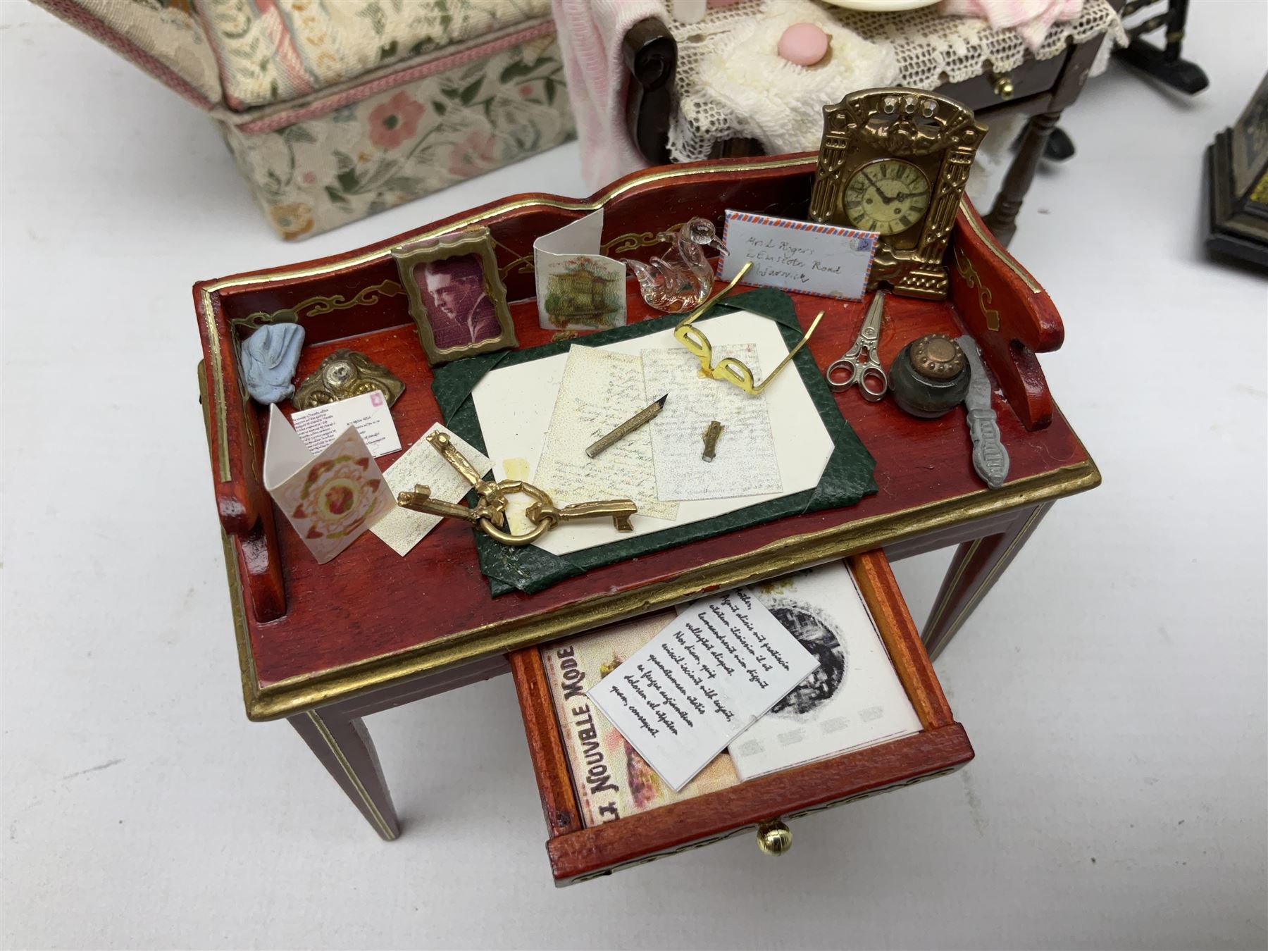 Collection of miniature dolls house furniture, to include five drawer chest painted with blossom, cream and gilt double door mirrored wardrobe, four piece lacquered style desk set, three piece suite, writing desk, wash stand, Knoll style sofa etc (14)