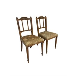 Pair Edwardian oak dining chairs, cresting rail carved with kylix over fluted columns, upholstered seat raised on square tapering supports with spade feet