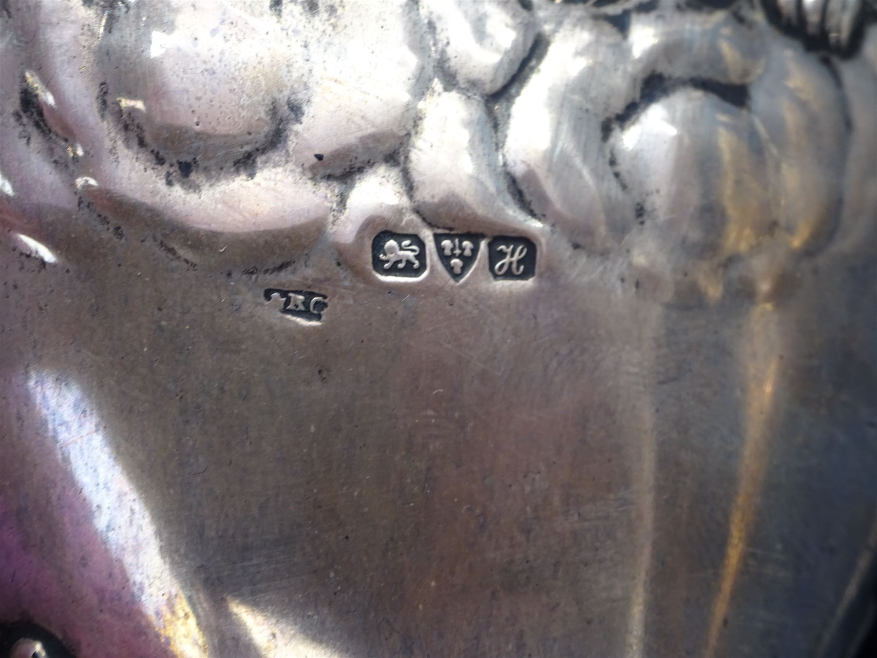 Four piece Edwardian silver mounted dressing table set, comprising hair brush, hand mirror, shoe horn and clothes brush, each embossed with cherubs, hallmarked Chester 1908, makers mark indistinct, together with a silver comb holder, hallmarked, contained within tooled leath, silk and velvet lined fitted case, 