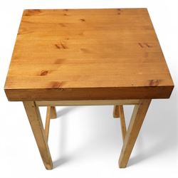 Mid-20th century pine butcher’s block, the thick laminated rectangular top raised on square supports united by side stretchers