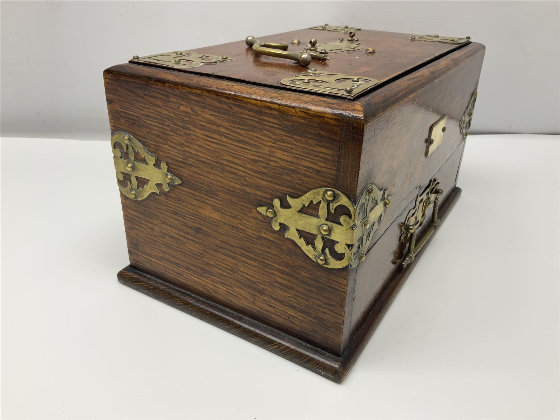 Brass mounted oak humidor, the slide action top opening to a base drawer, cedar lined with central compartment and striker, the drawer stamped Rd 107198, H17cm, D18cm