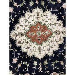 Turkish Cappadocia silk inlaid ivory ground rug, the central medallion in indigo field decorated with trailing foliate and scrolling, the border with repeating panels and foliate motifs 