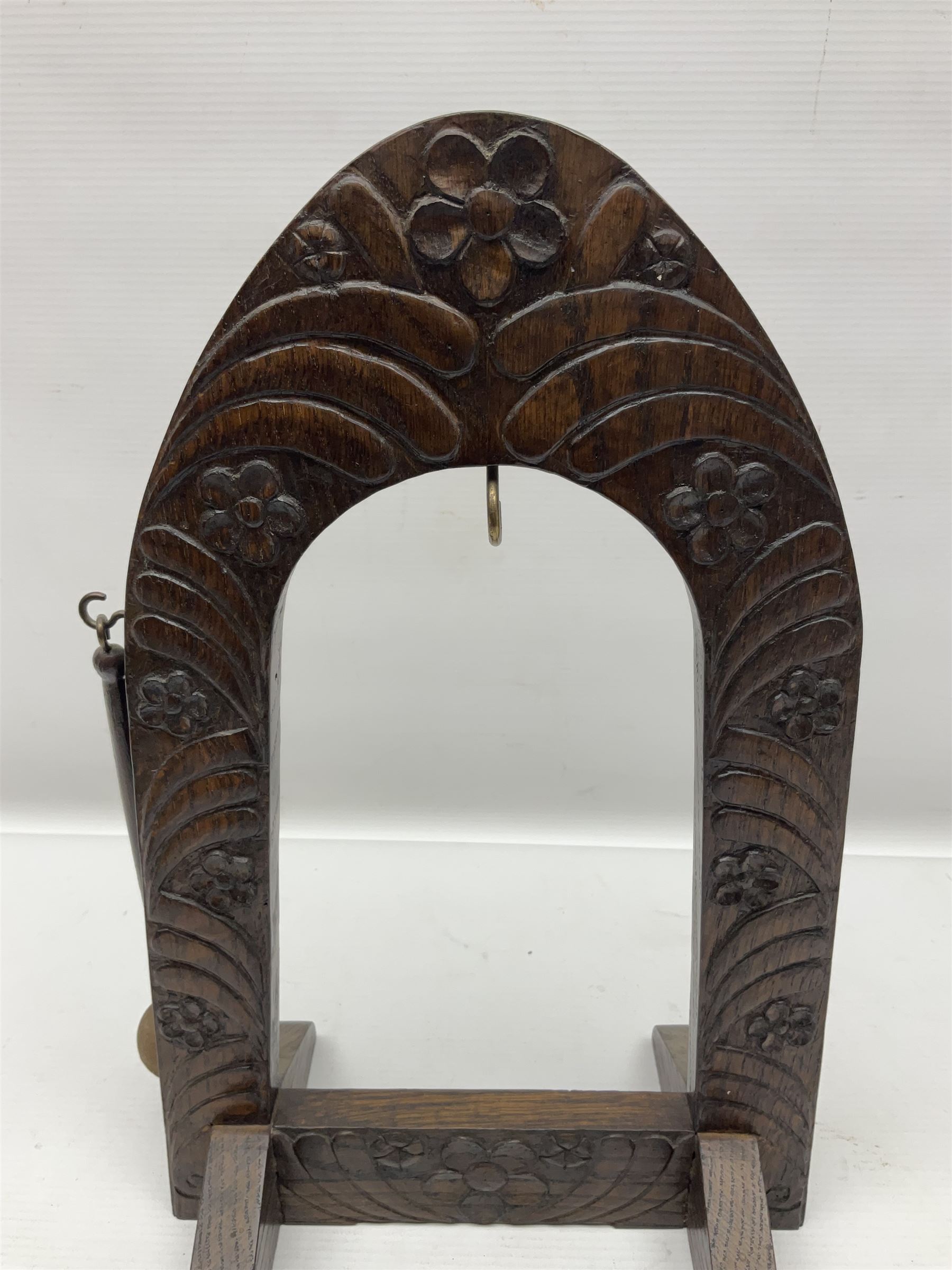 Chinese brass temple bell, decorated in high relief with a a dragon chasing a flaming pearl, within a carved floral hardwood stand, H36cm