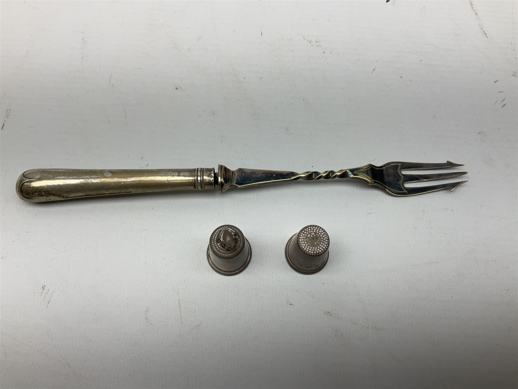 Two hallmarked silver thimbles to include late 20th century example with frog surmount stamped Clive & Clarissa Cooke, London, silver plated fork with hallmarked silver handle, together with a quantity of silver plated and other metal ware