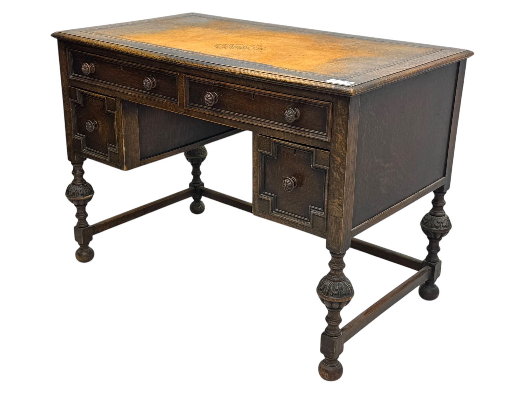 Early 20th century Jacobean design oak desk, with rectangular top inset with worn tooled leather, two frieze drawers over pedestals each fitted with a pair of panelled drawers, turned handles, on carved and fluted tapering legs united by stretchers 