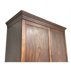 George III mahogany Gentleman's linen press, the projecting cornice over two panelled cupboard doors enclosing three sliding trays, the base fitted with two short over three long graduating cock-beaded drawers, lower moulded edge over bracket feet