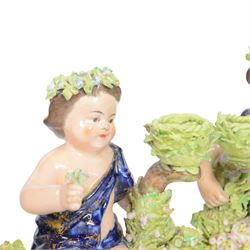 Pair of 19th century Stevenson and Hancock Derby figural chambersticks, each modelled as a seated cherub with arm around foliate encrusted sconce, marked beneath, H18cm