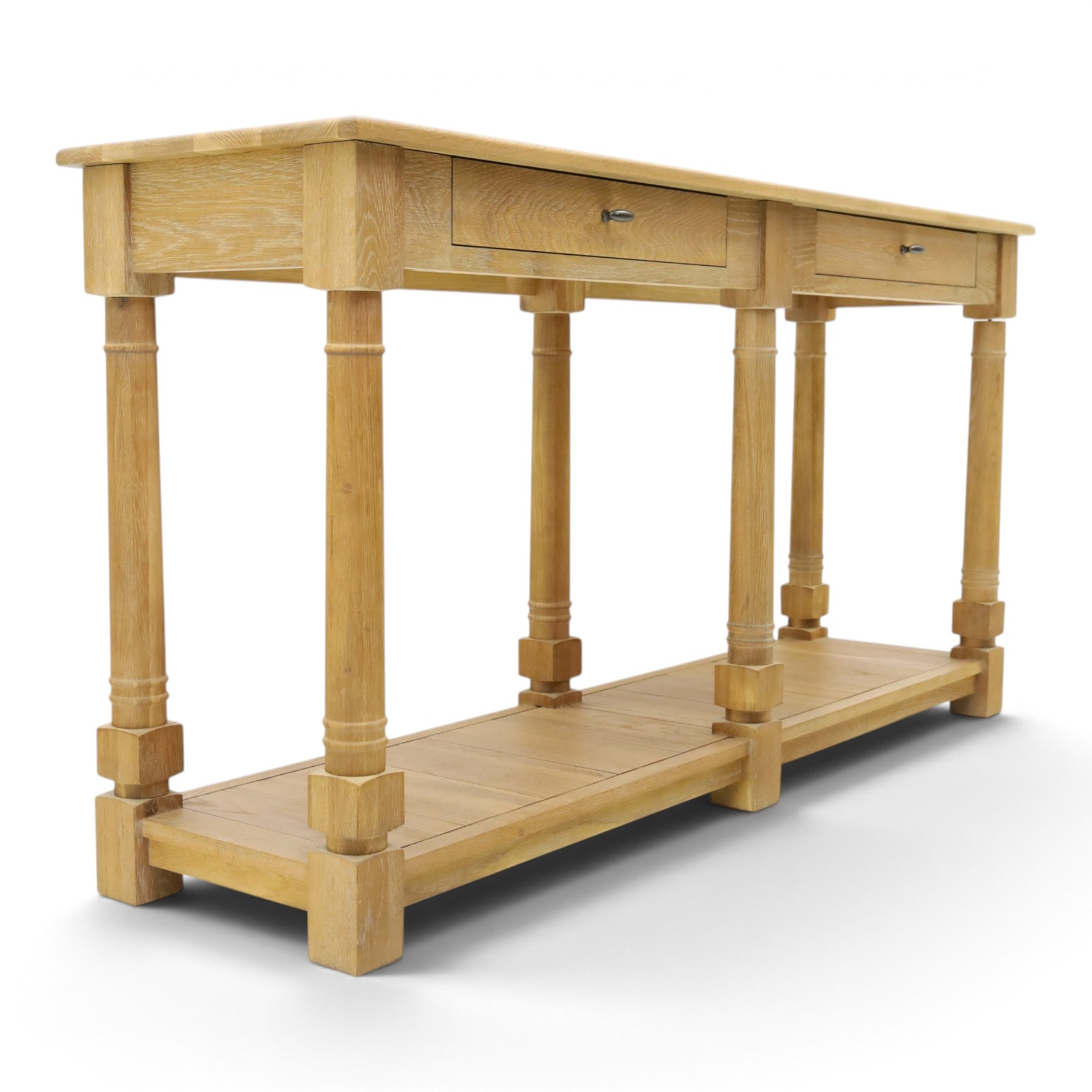Neptune - 'Edinburgh' limed oak console table, with two
soft close drawers raised on ring-turned column supports,
with a pot shelf raised on square feet