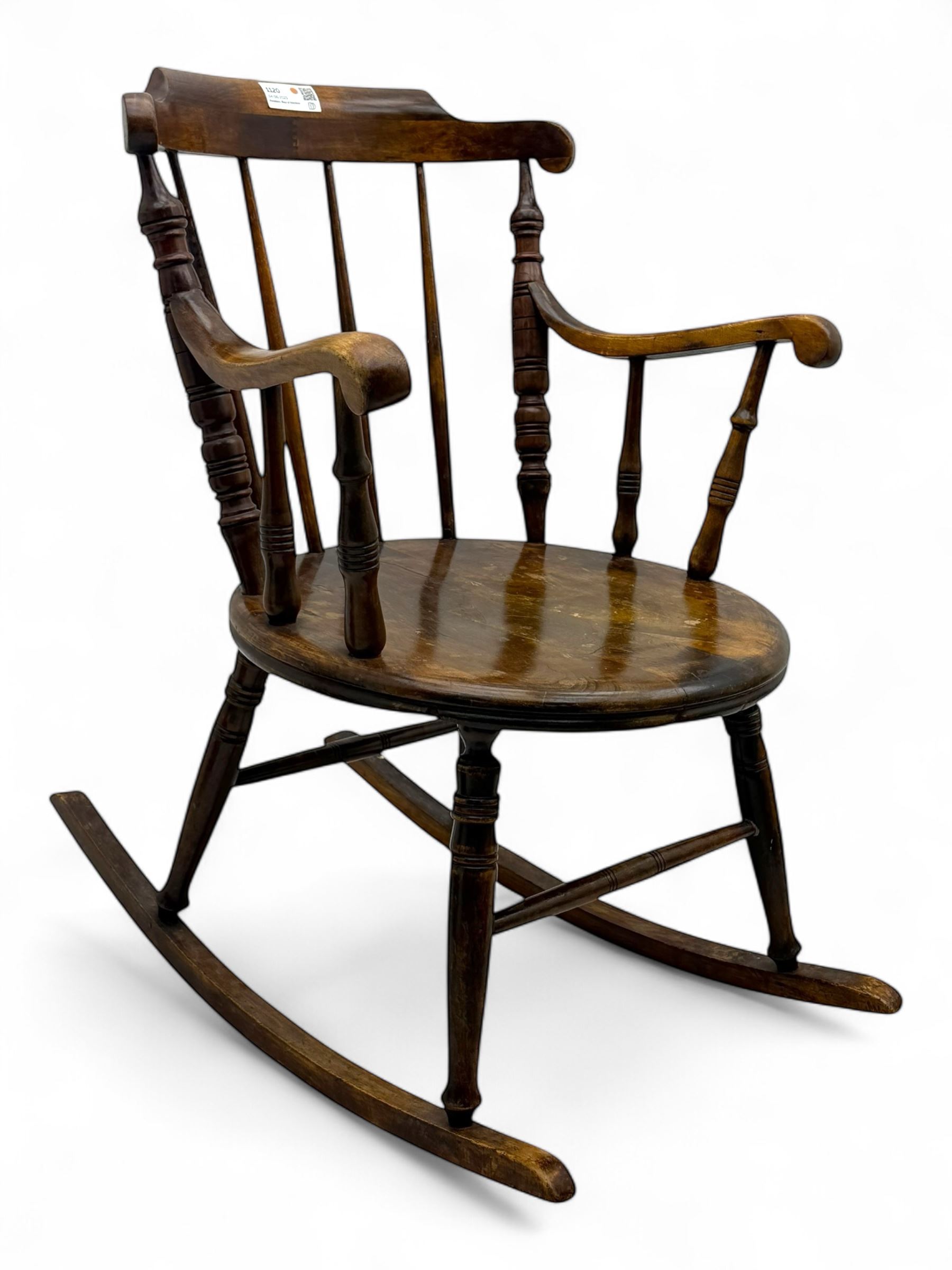 Late 19th century elm and beech Windsor rocking chair, with shaped top rail over turned spindles and curved arms, circular seat raised on turned legs united by stretcher on rockers