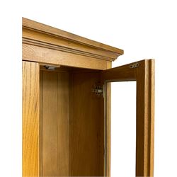 Tall oak display cabinet, projecting cavetto cornice over two glazed doors and single drawer, on bracket feet