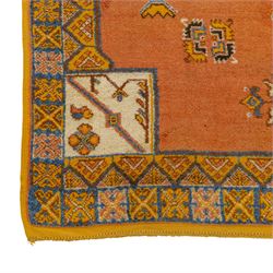 Turkish Anatolian hand-knotted carpet, salmon ground centred by a blue and cream octagonal medallion, scattered with geometric floral and tribal motifs, cream spandrels and yellow geometric border