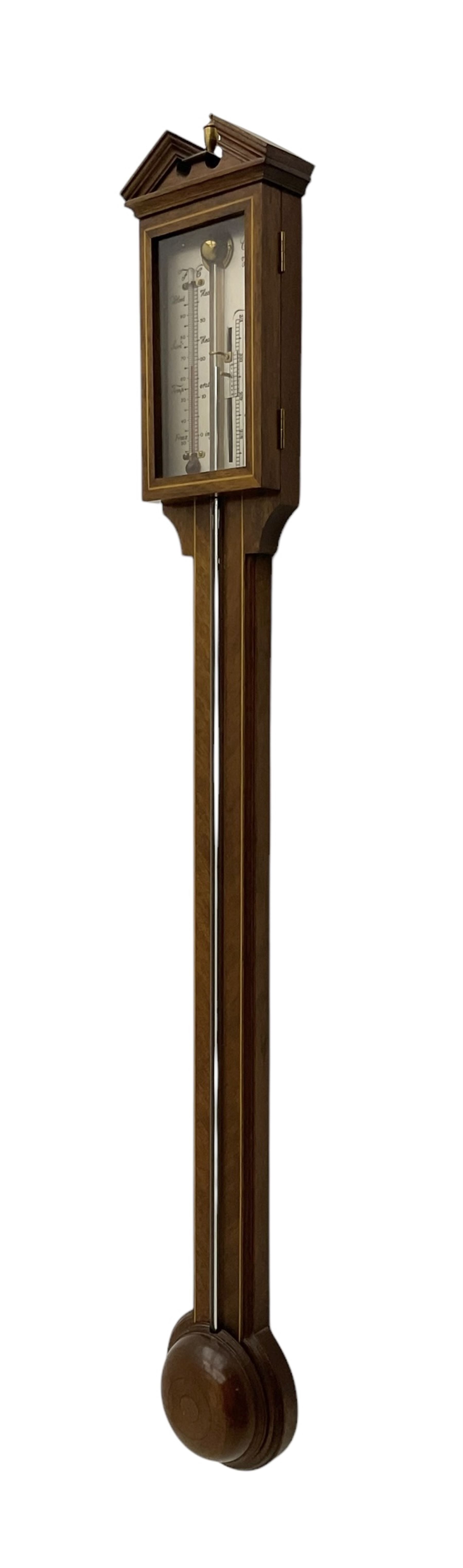 Comitti-20th century mercury stick barometer in an 18th century style mahogany case with satinwood stringing, with a broken pediment, brass finial and round base, silvered register with recording vernier, weather predictions and a centigrade/Fahrenheit spirit thermometer enclosed within a glazed door, visible tube with a bulb cistern and turned mahogany cover.
Mercury clean and present with no air locks.