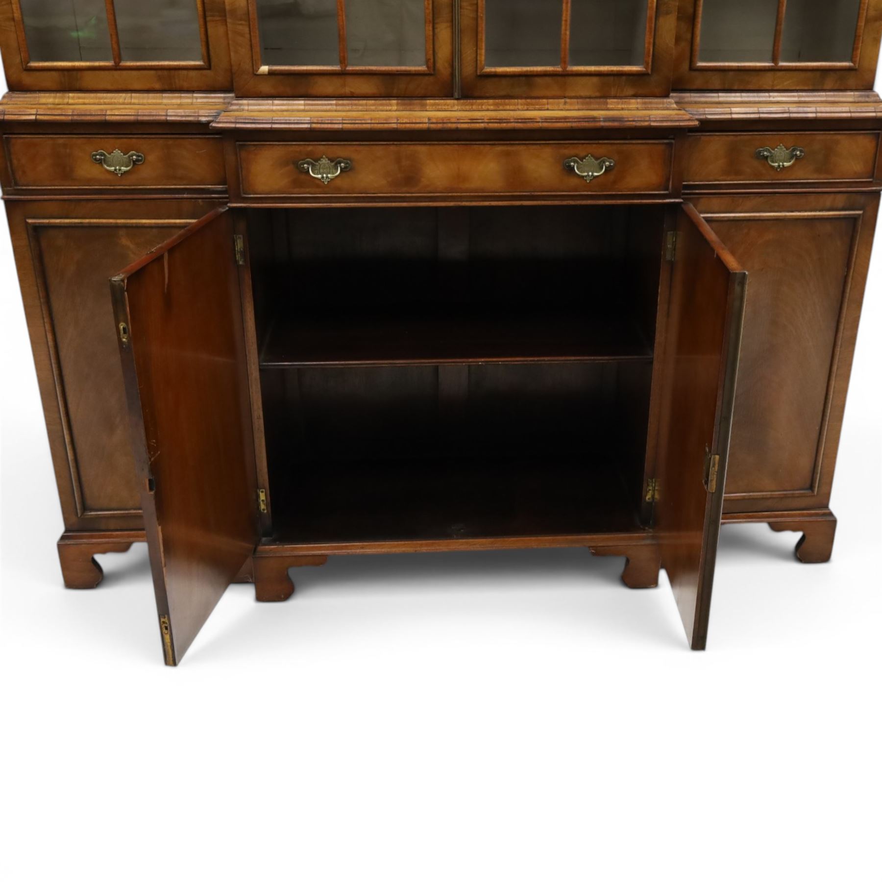 Georgian design mahogany breakfront bookcase on cupboard, projecting cornice over four arched astragal glazed doors, base fitted with three drawers over panelled cupboards, raised on bracket feet