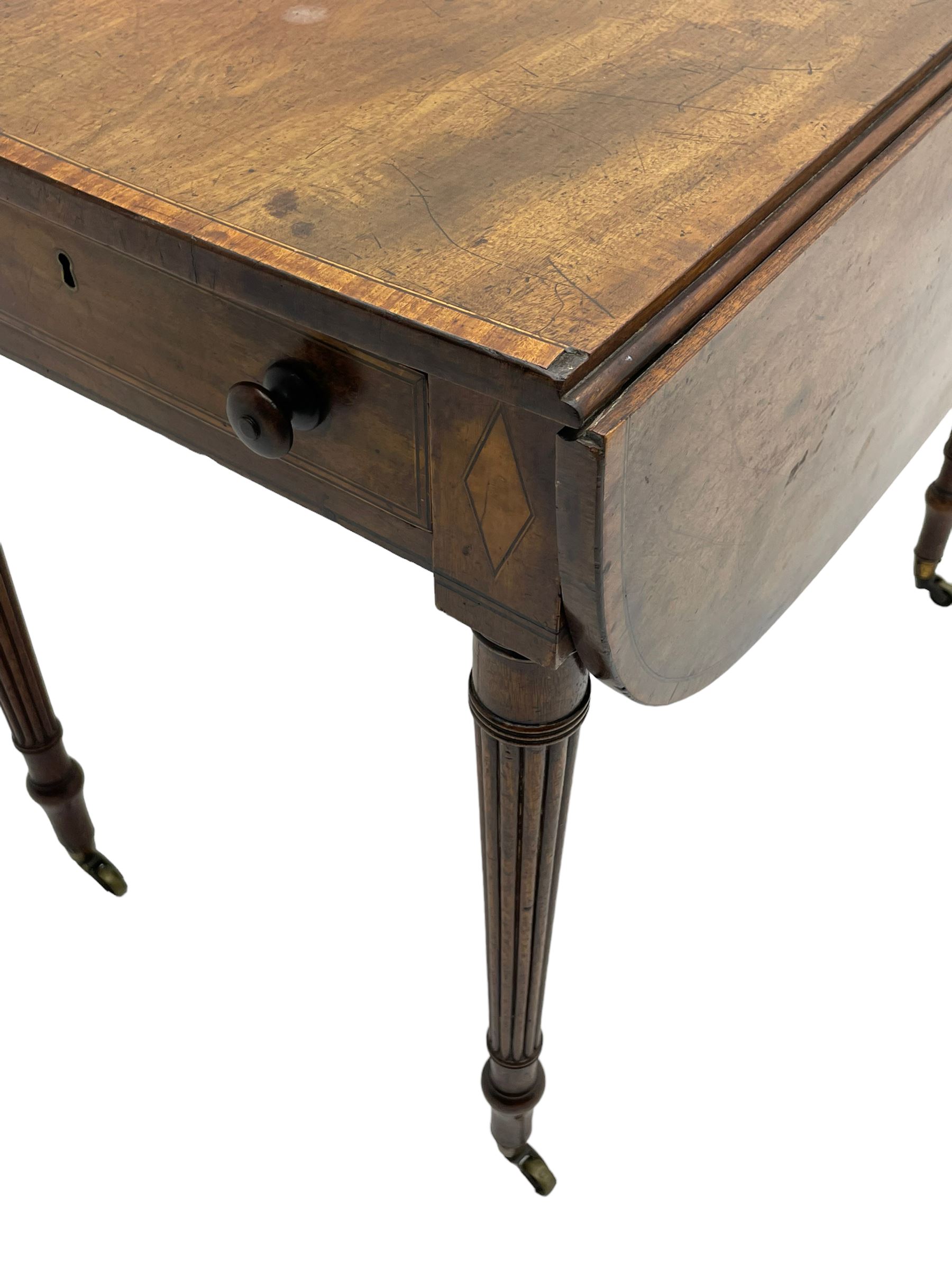 George III mahogany Pembroke table, drop-leaf oval top with satinwood band, fitted with single end drawer, inlaid with satinwood lozenge motifs, on turned and reeded supports with brass cups and castors