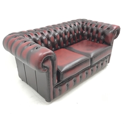 Two seat Chesterfield sofa upholstered in deep buttoned red leather, W165cm