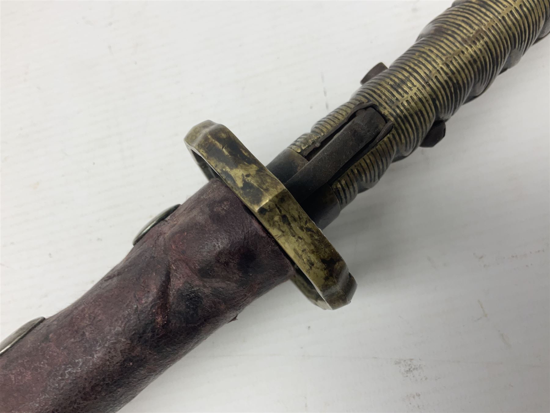 Copy of a WWII Japanese NCO sword, the 65cm slightly curving blade stamped with pseudo Japanese characters and cast brass simulated cord bound grip; in officer's leather bound field scabbard L97cm overall