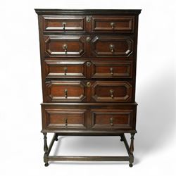 Jacobean style oak chest on stand, four full-length graduated drawers decorated with geometric mouldings, brass pear drop handles and escutcheon, the stand with two drawers above turned legs on a stretcher base on all sides, raised on pear-shaped feet, 18th century and later 

 
