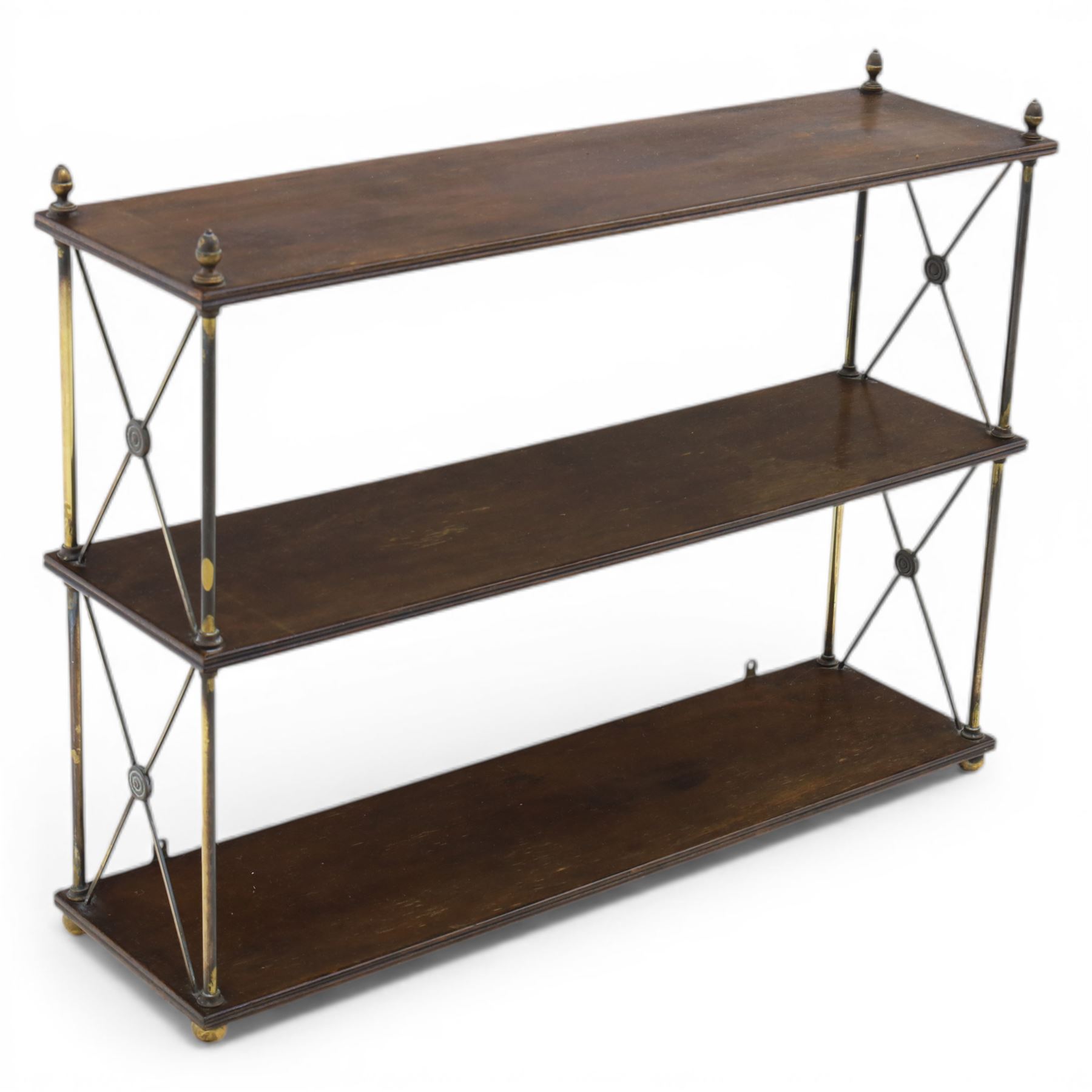 Regency brass and mahogany wall shelves circa 1820, the three shelves contained within a brass cross brace with brass finials, with wall fixings 
